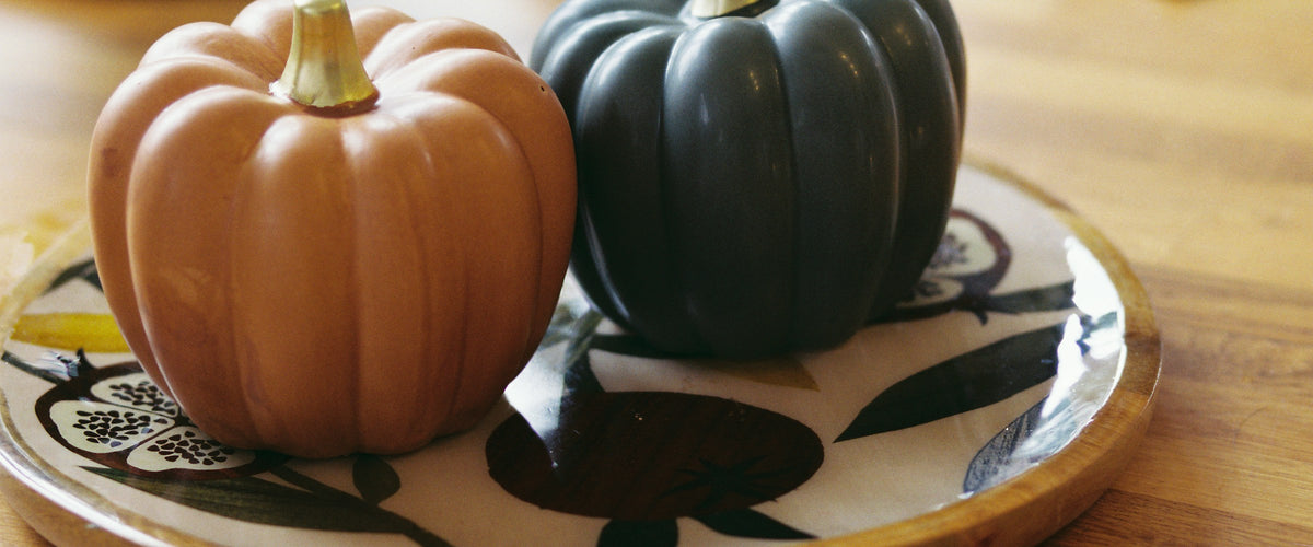 Orange and slate ceramic pumpkins on a leaf-patterned plate