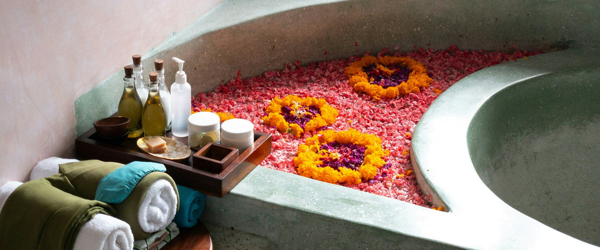 Spa bath with marigold petals, towels and bath accessories
